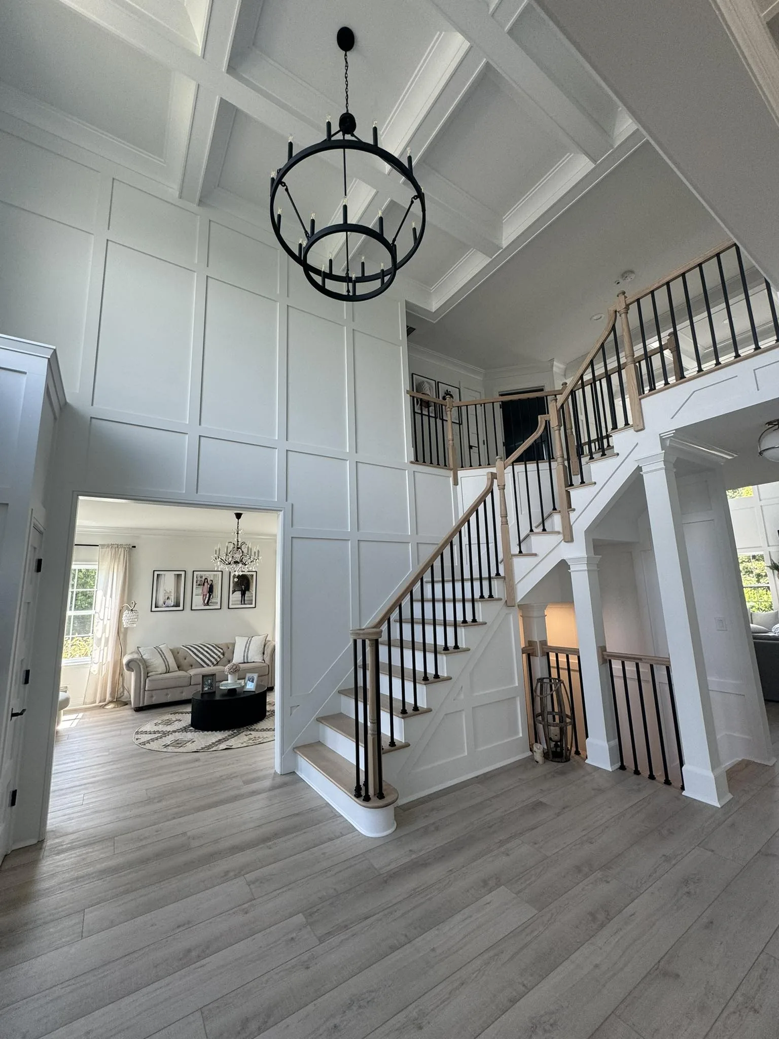 Grand entry hall with coffered ceiling, panelled walls and a custom staircase